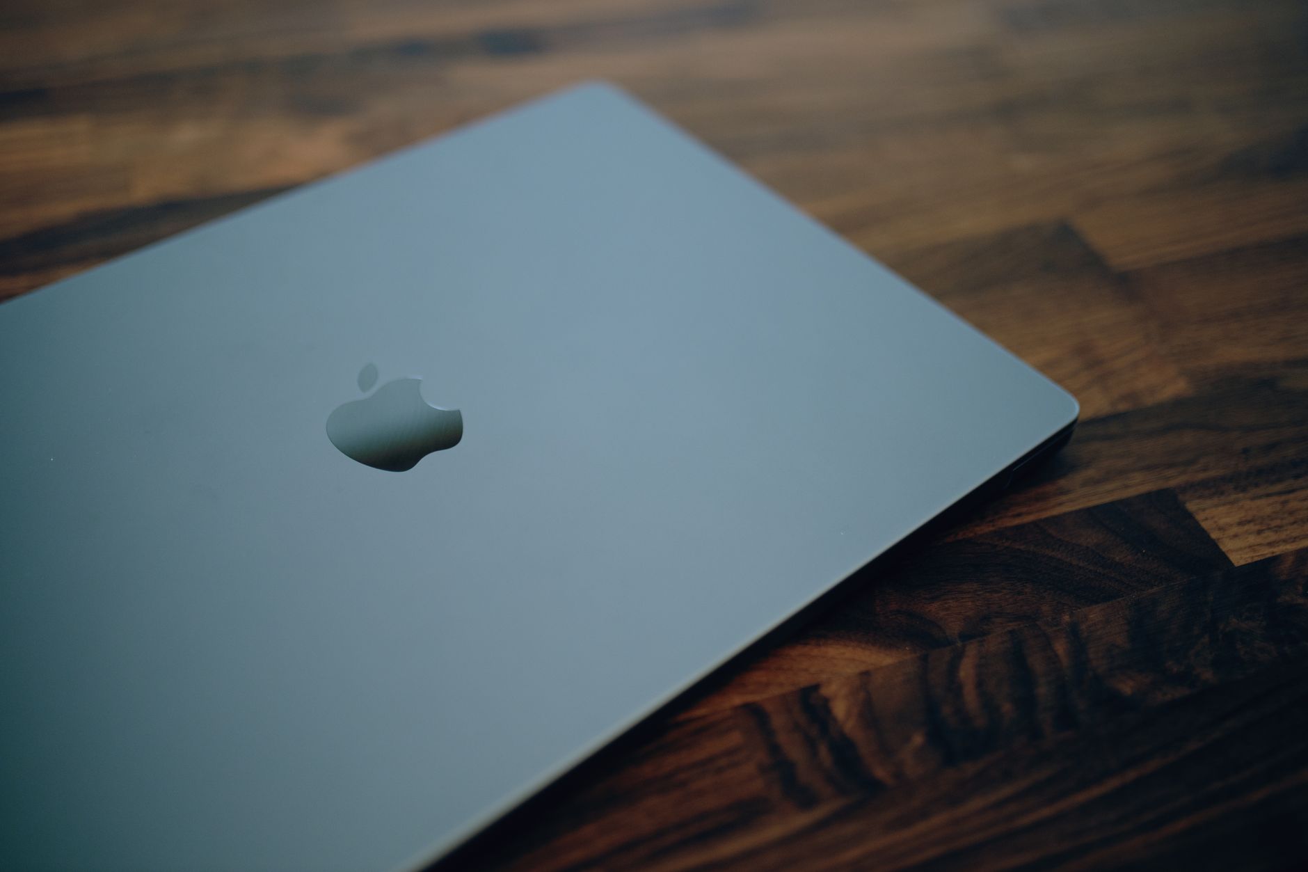 Apple CEO John Ternus speaking on stage beside a MacBook Pro display at a product launch event