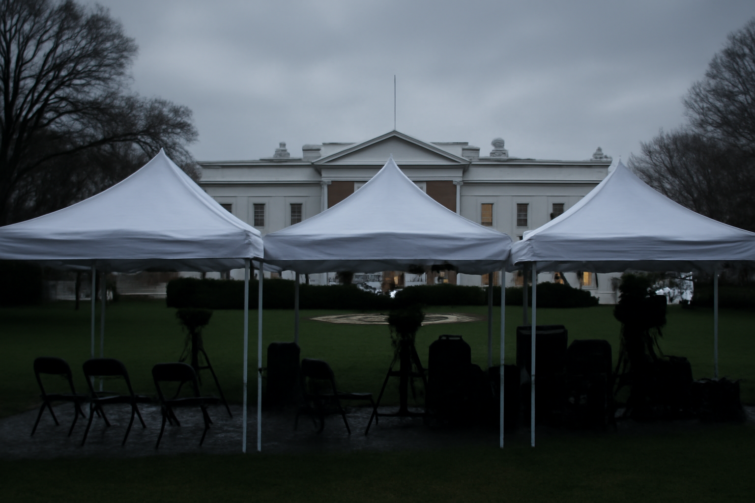Dark, unoccupied CNN and MS Now broadcast tents on the White House grounds at dawn.