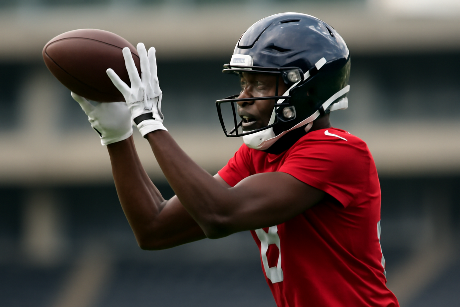 NFL wide receiver in Houston Texans practice jersey catching a pass during a team workout