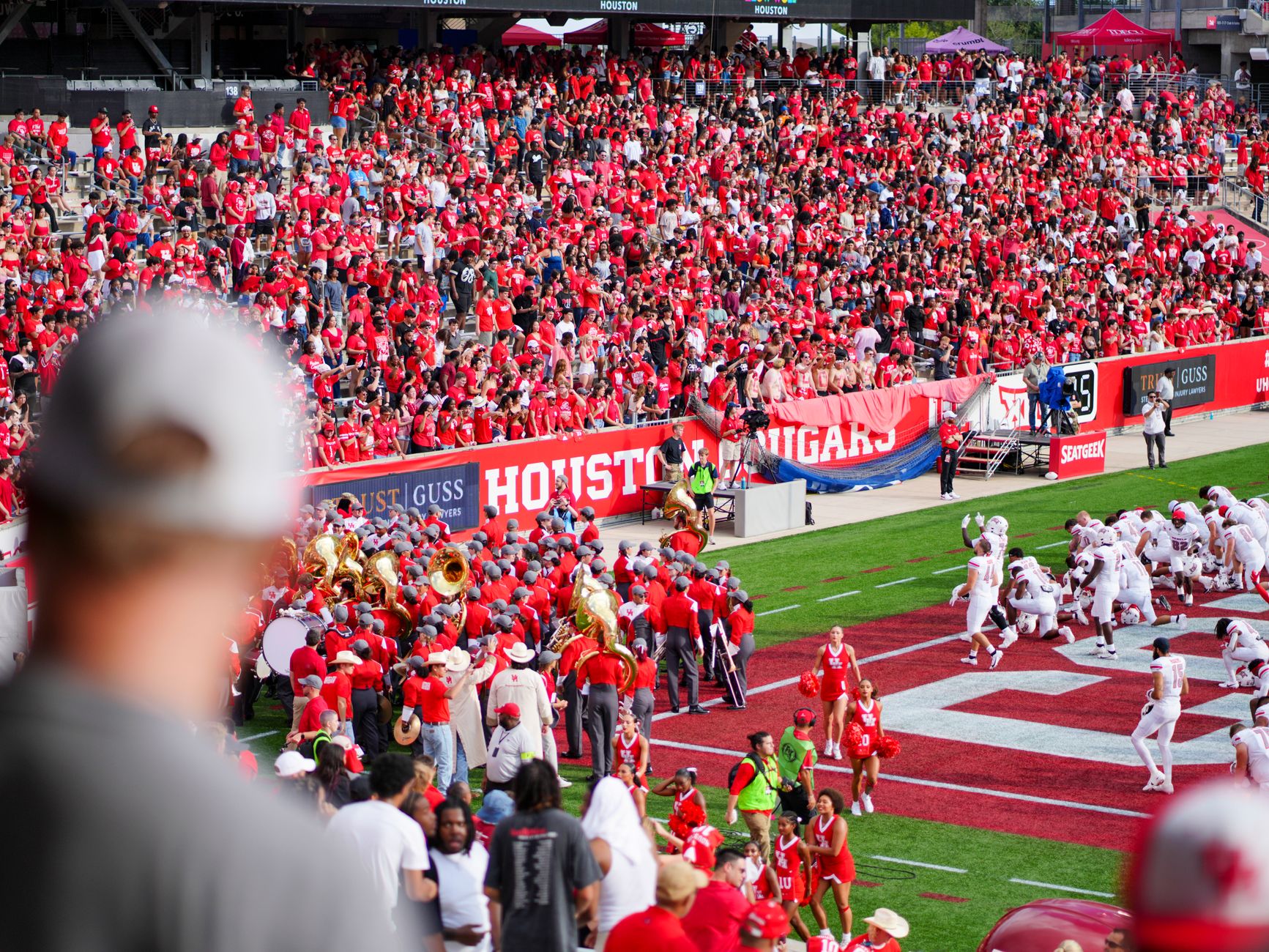 Empty college football stadium under stadium lights with a coach's headset on the sideline bench