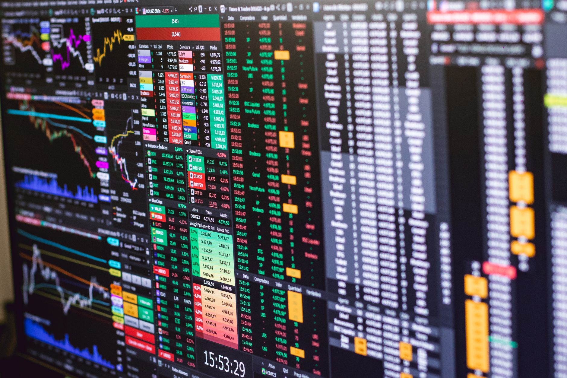 Digital stock index boards and an oil price chart displayed side by side in an Asian financial district trading floor