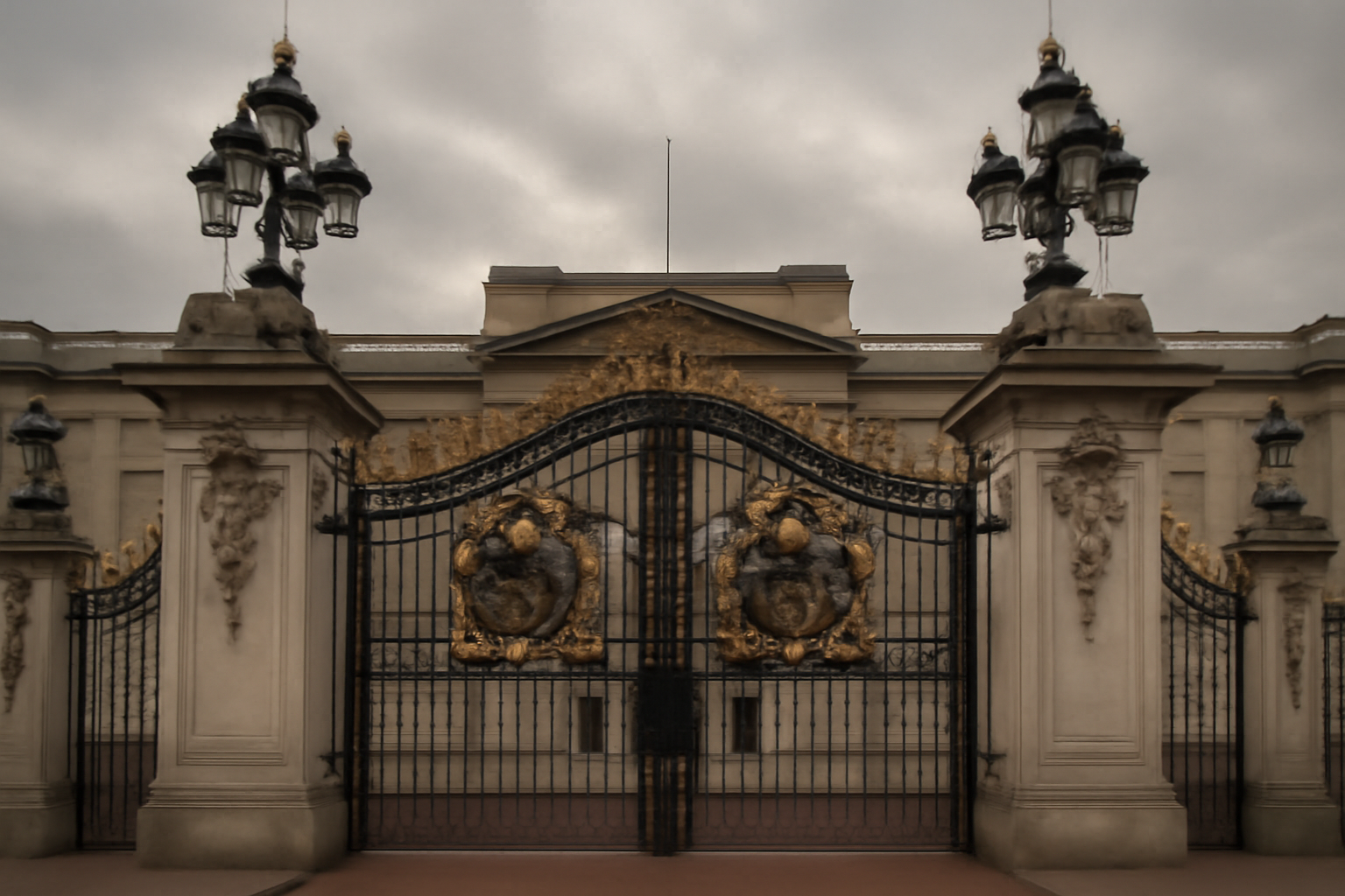 Buckingham Palace gates in London under overcast sky