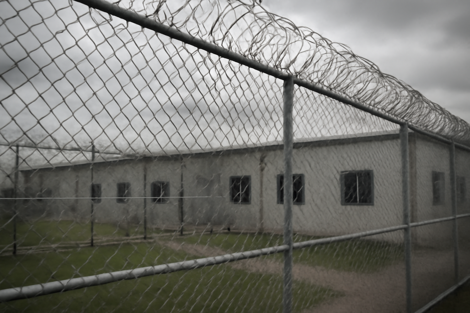 Detainees standing near a window inside an immigration detention facility