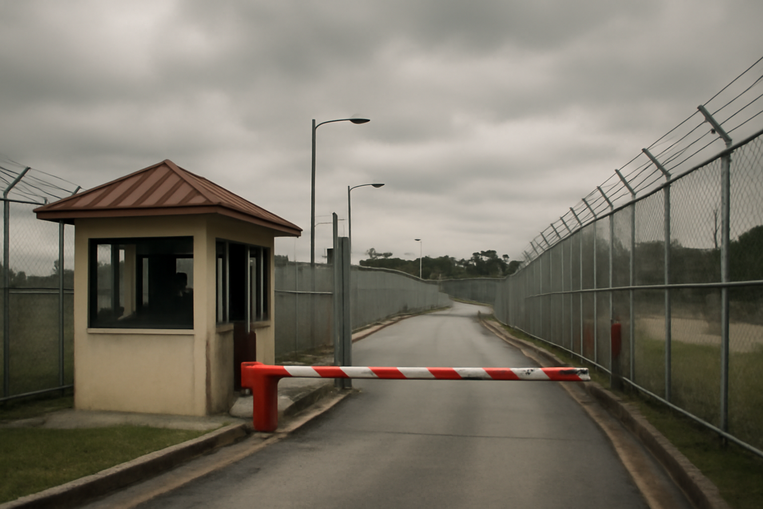 Chain-link gate and guard booth at a U.S. Marine Corps base entrance in Okinawa, Japan