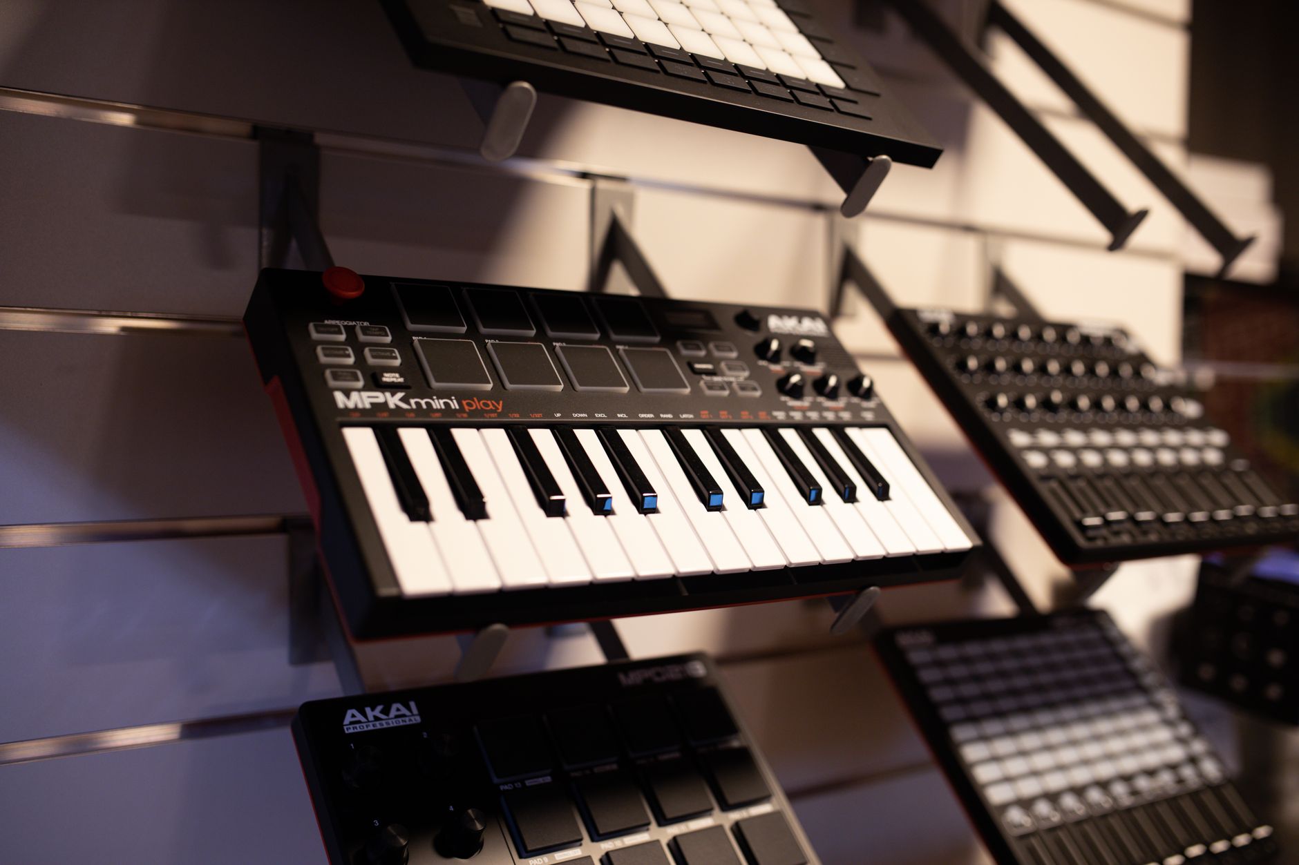 A compact 37-key sampler keyboard with pitch and mod wheels sitting on a studio desk