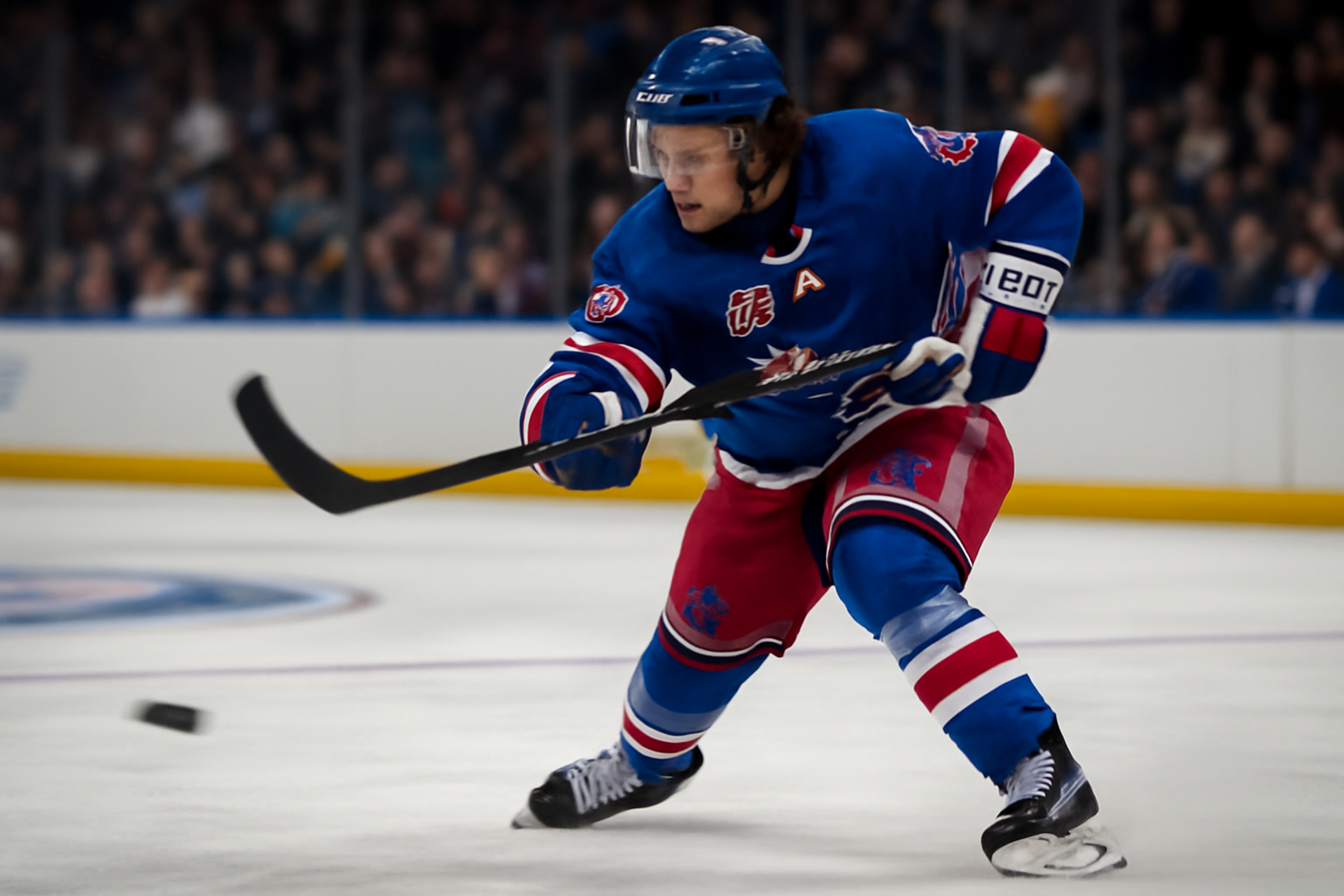 New York Rangers forward in home jersey shooting the puck during a preseason hockey game