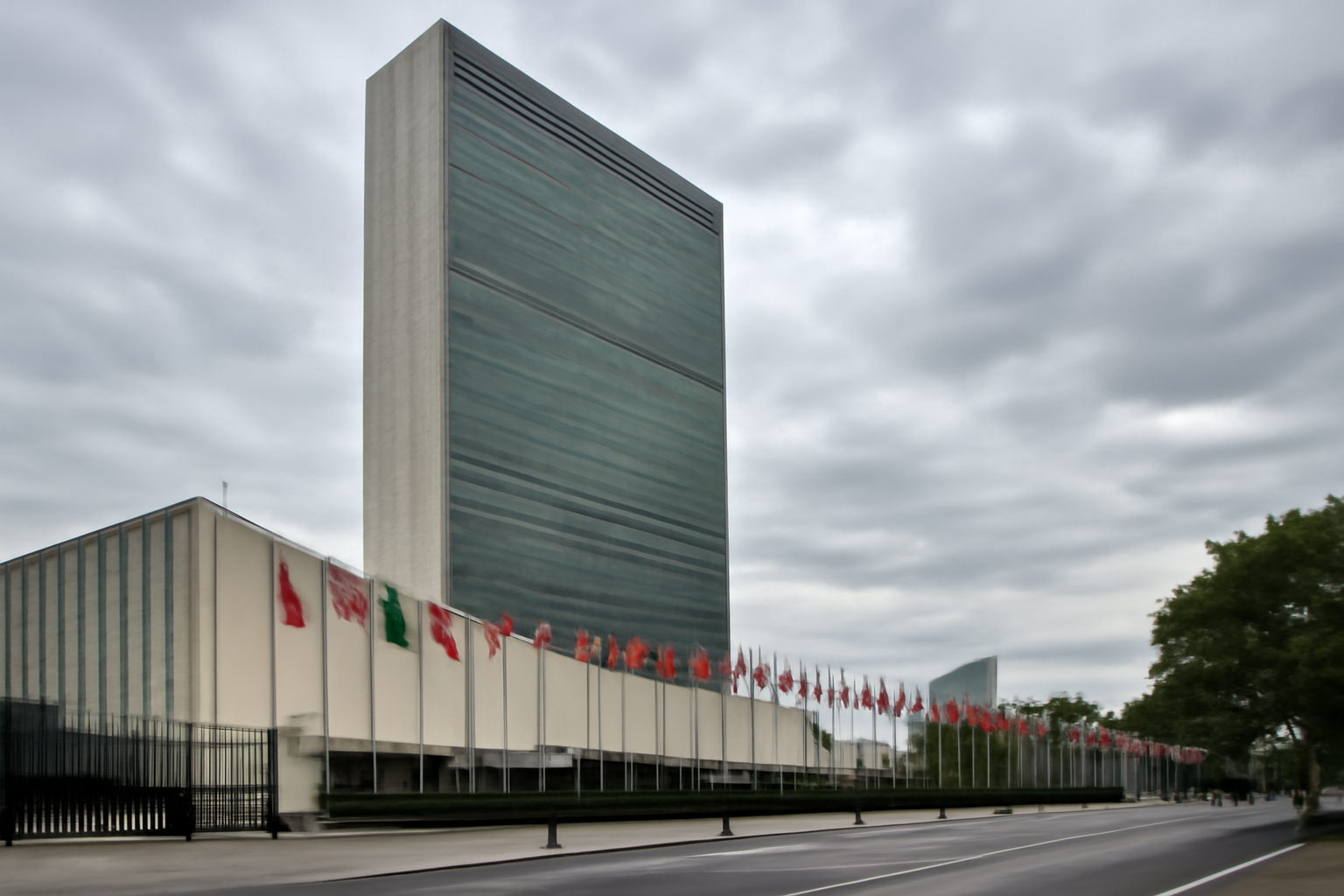 United Nations headquarters building in New York with flags flying outside during the General Assembly session