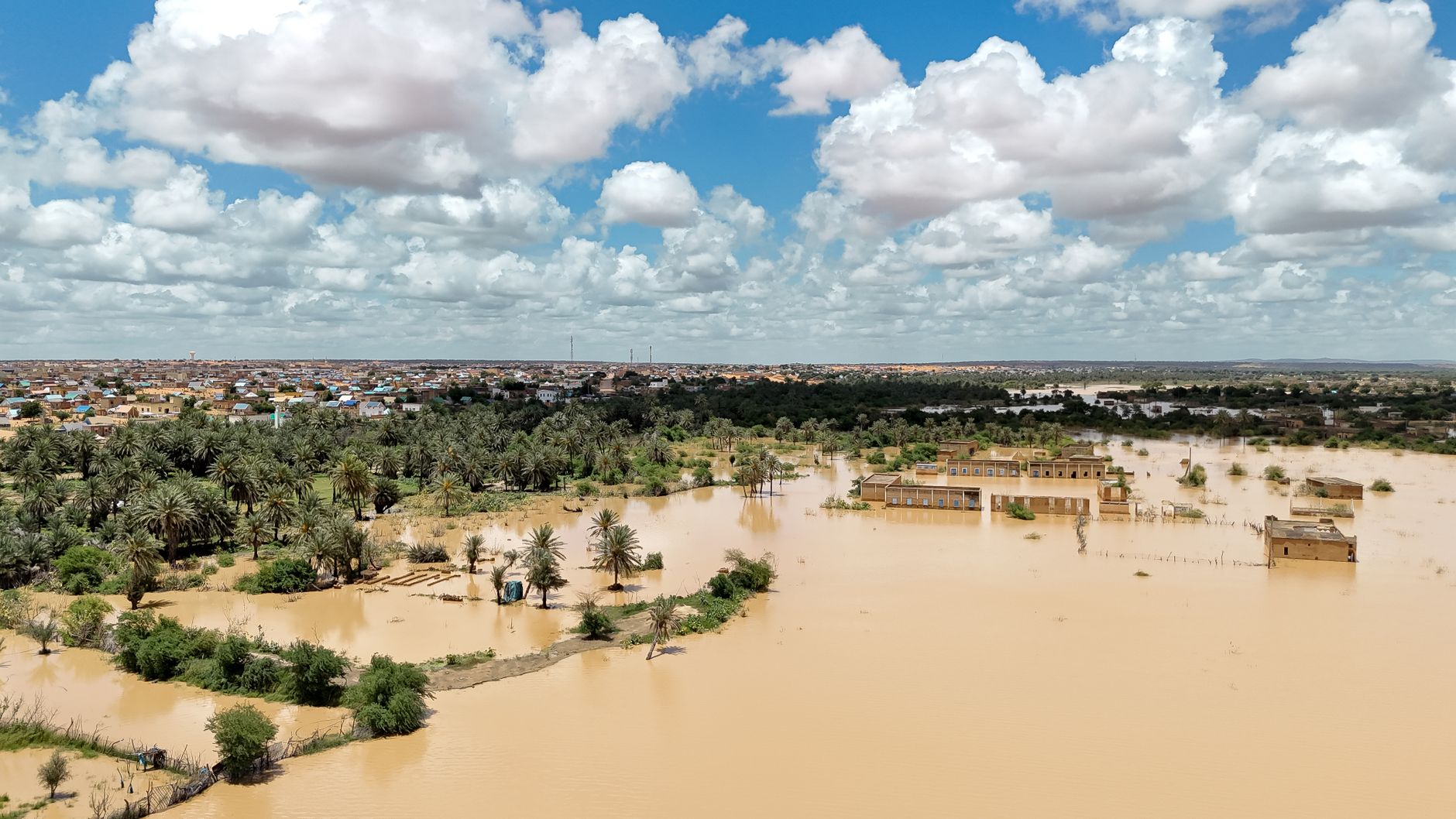 Riverside town along the Shabelle River in Somalia under a cloudy sky before seasonal rains