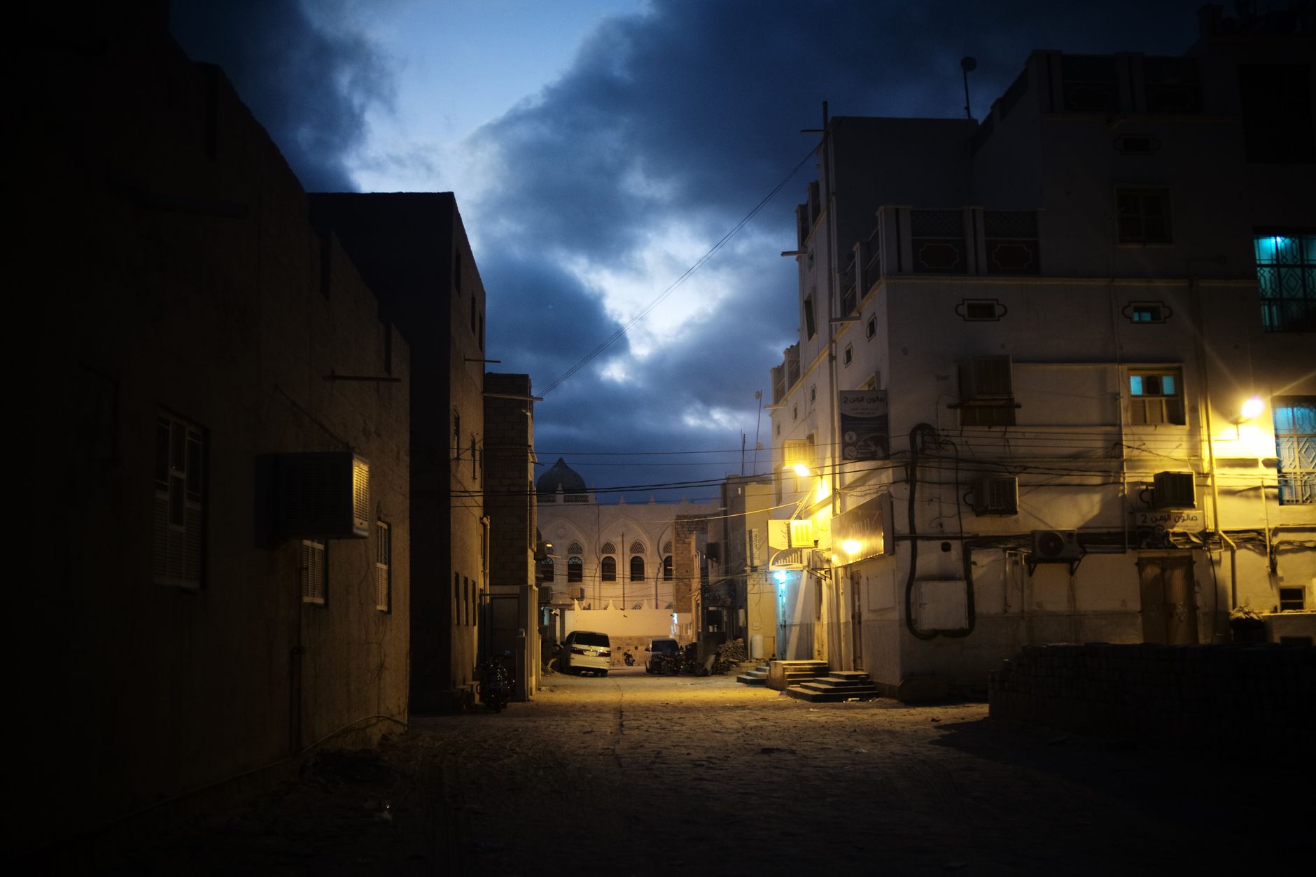 Schoolgirls walking toward a classroom building in Taiz, Yemen, with damaged structures visible nearby