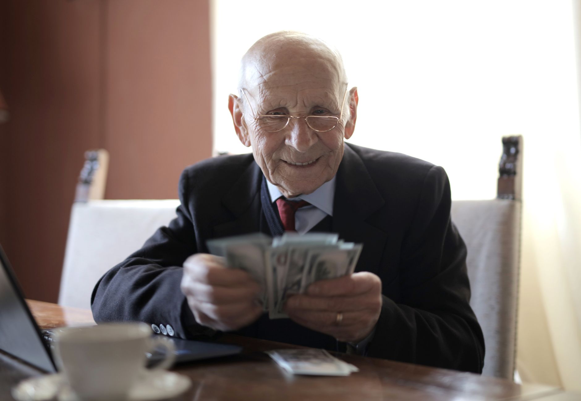 An older couple reviewing retirement paperwork and a pension statement at their kitchen table