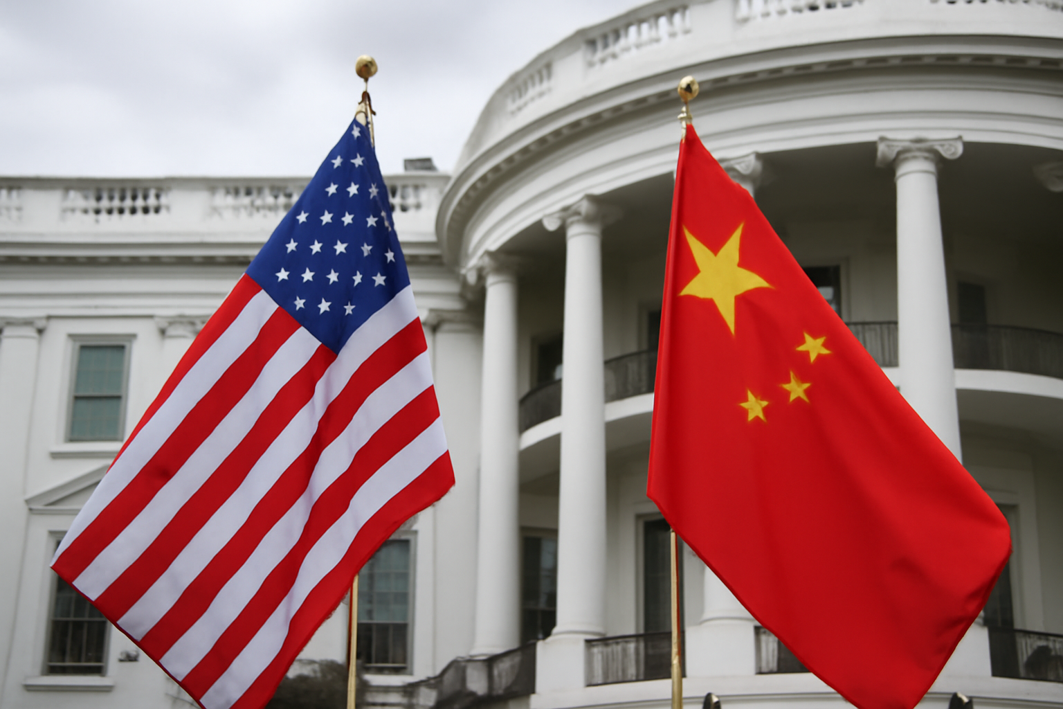 American and Chinese flags positioned near the White House exterior under daylight