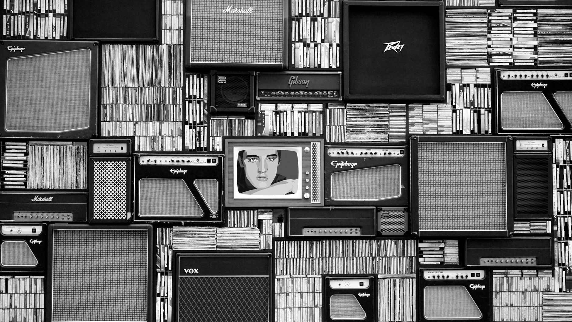 A vinyl record resting beside a laptop displaying abstract digital network lines in a dim newsroom setting