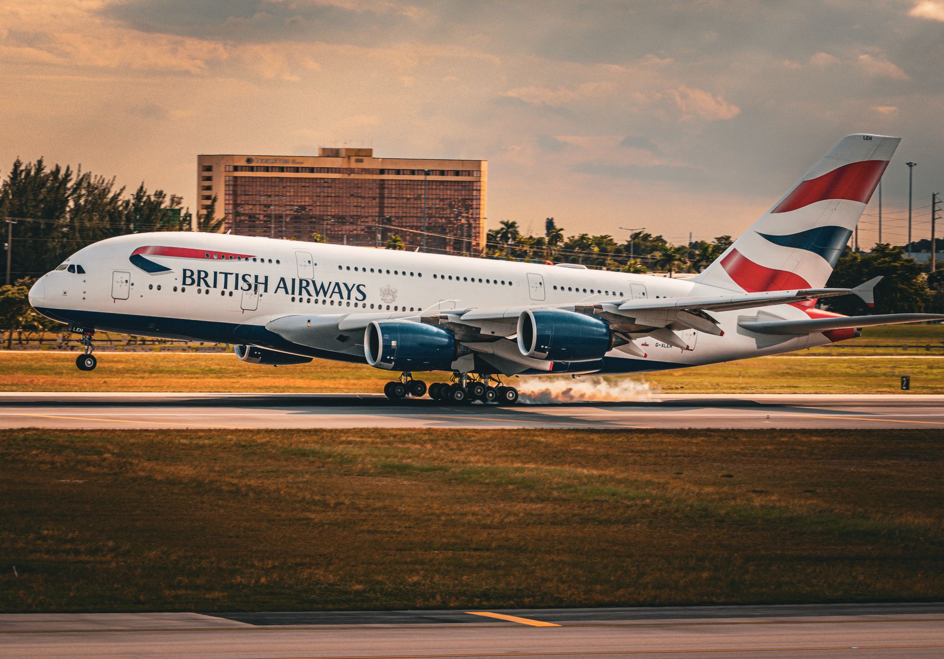 A private jet parked on a tarmac near a South American airport terminal at dusk