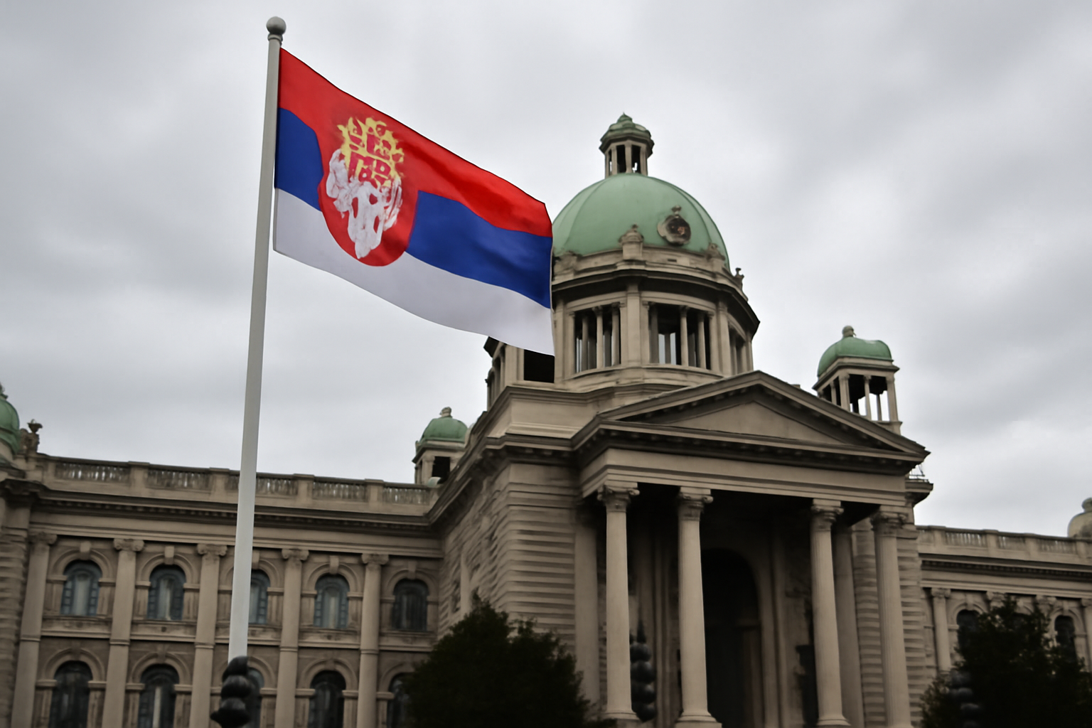 A government building facade in Belgrade with a Serbian flag against an overcast sky