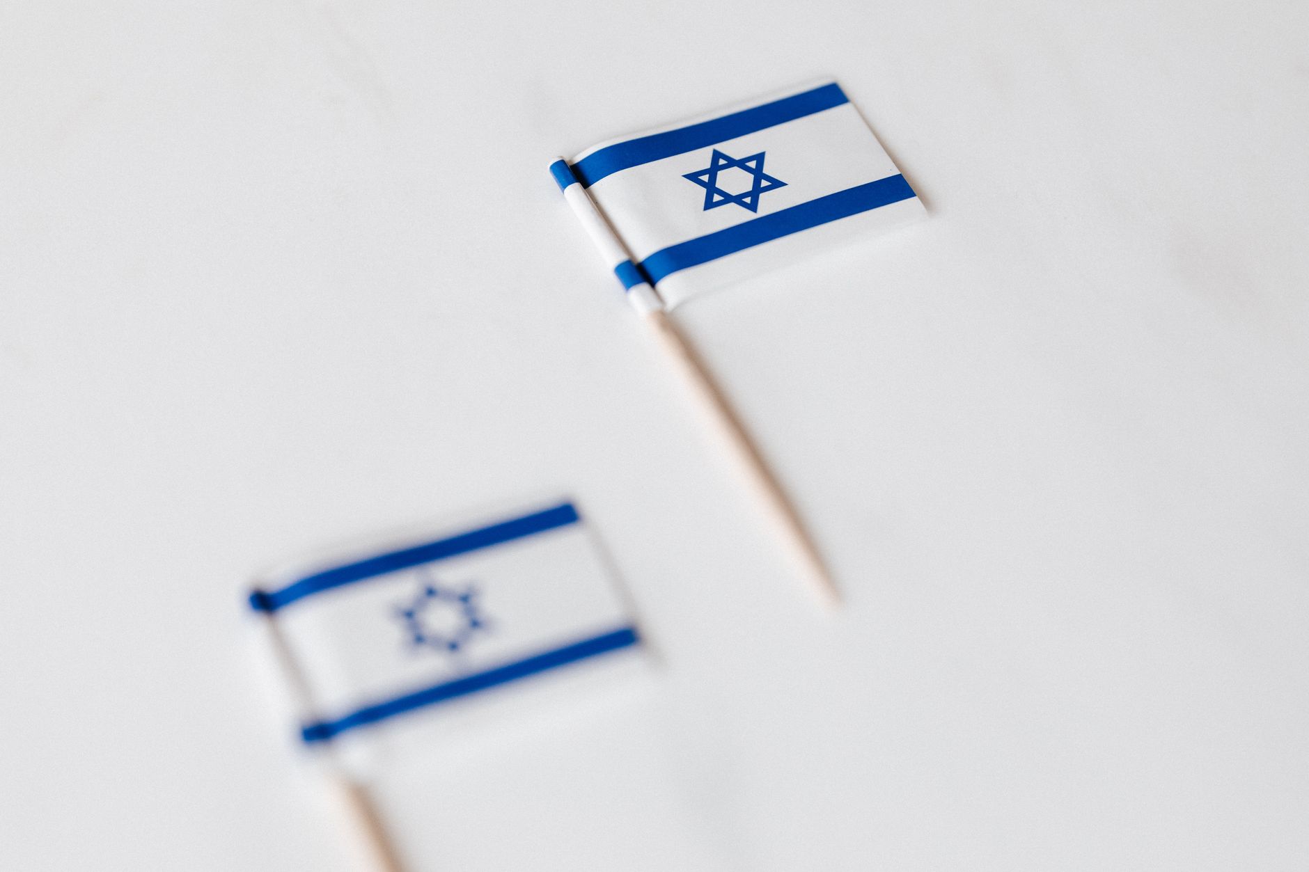 Israeli flag flying outside a polling location with a line of voters waiting