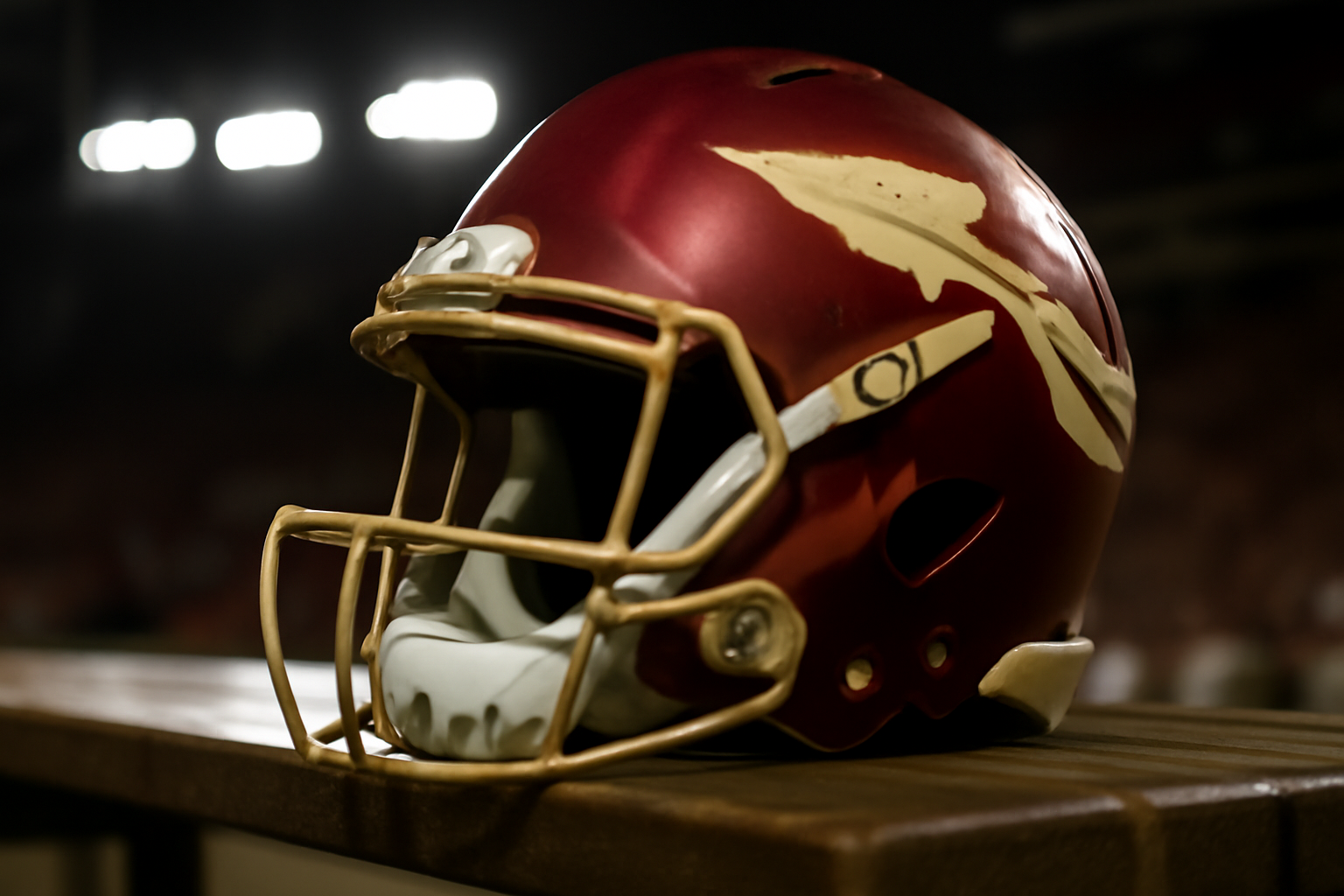 Florida State Seminoles football helmet and jersey on a locker room bench
