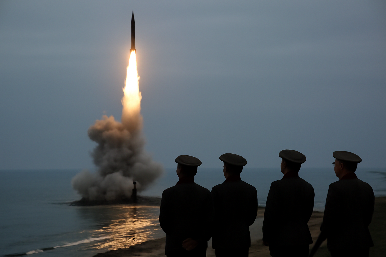 North Korean leader Kim Jong Un stands beside his teenage daughter observing a missile launch at an undisclosed coastal test site.