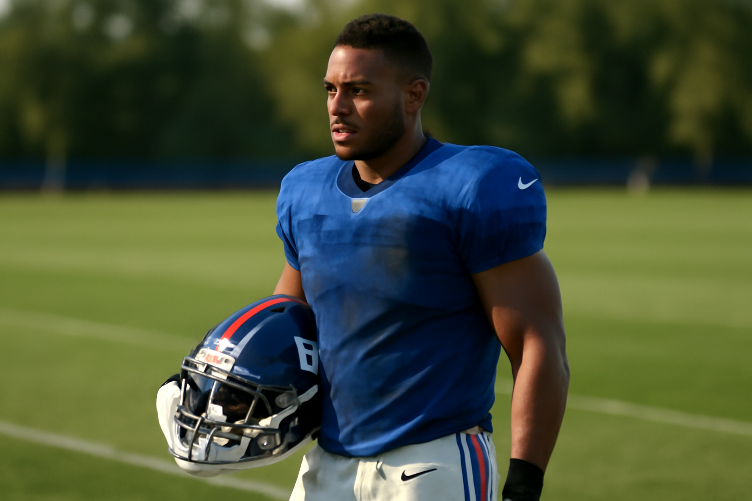 New York Giants running back in Giants uniform standing on the practice field sideline