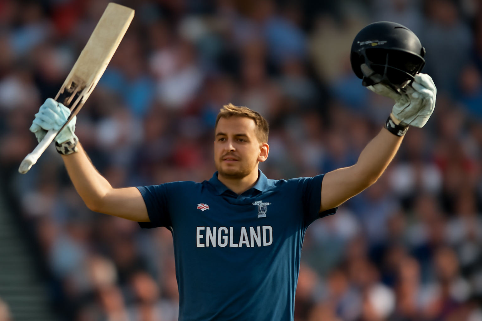 Cricket batsman in England kit raising his bat and helmet in celebration on the pitch at The Oval