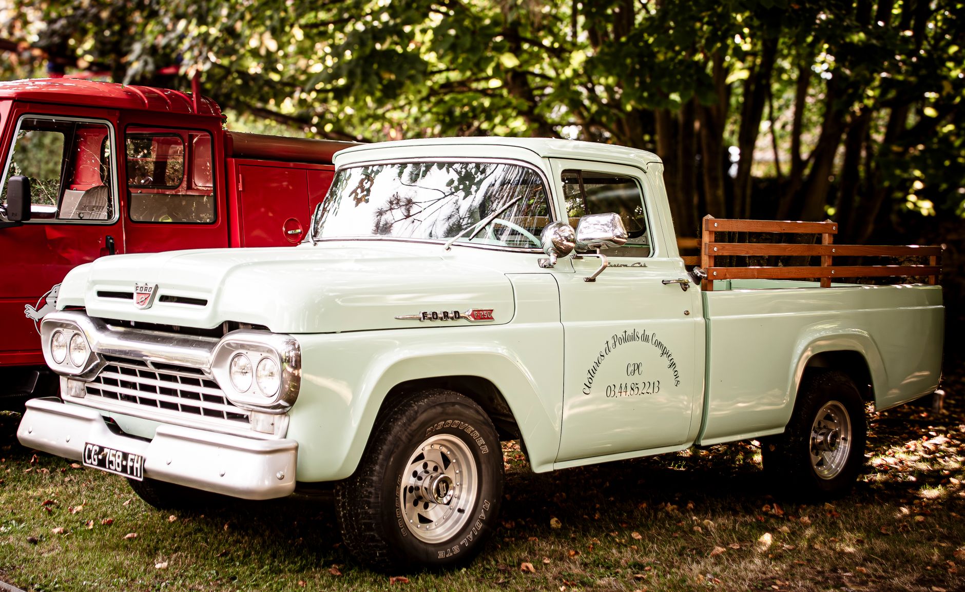 Ford Fathom electric pickup truck parked in a driveway connected to a wall-mounted home backup charger at dusk