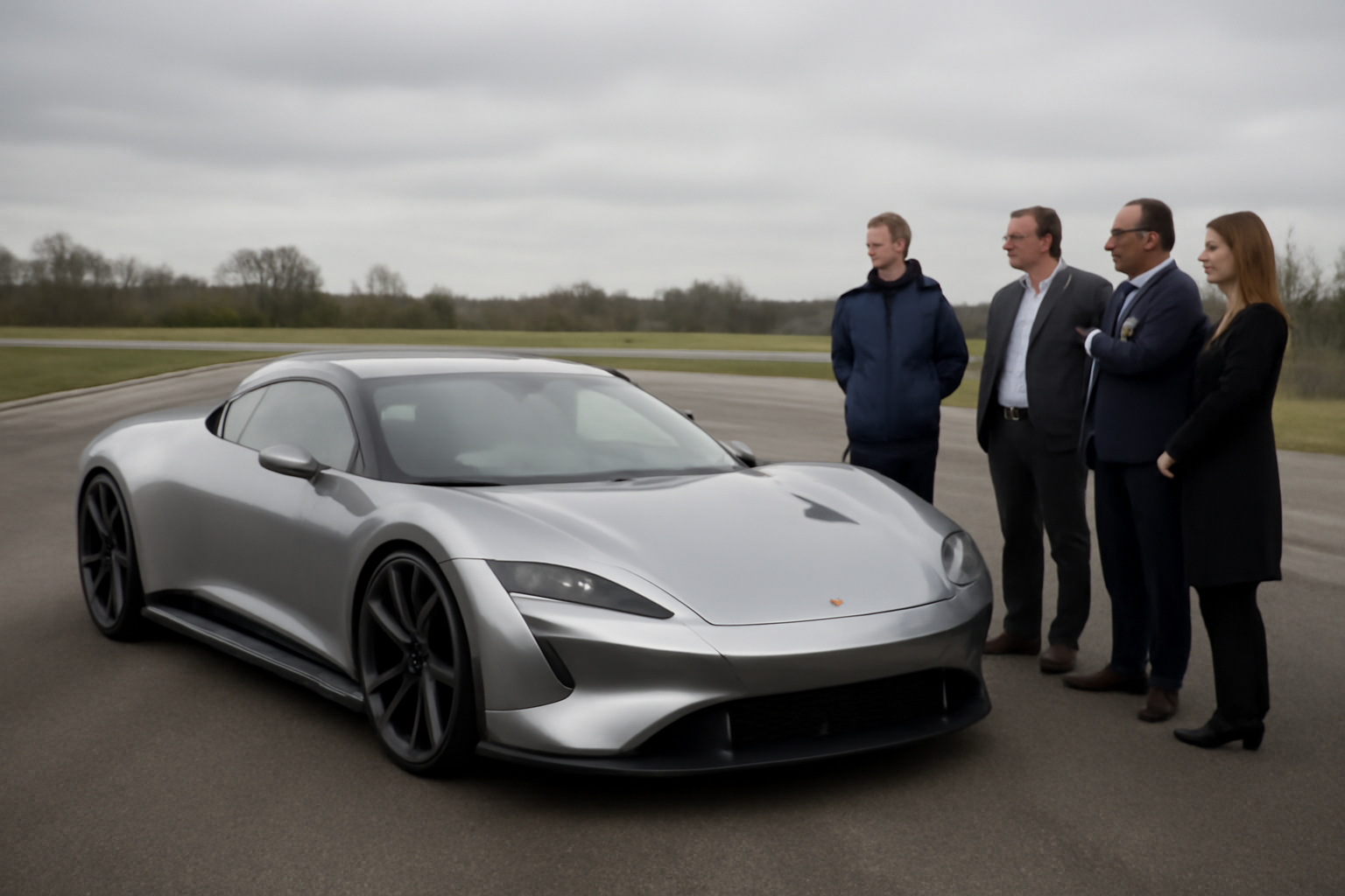 A lightweight electric sports car prototype on a test track in Warwickshire with engineers observing