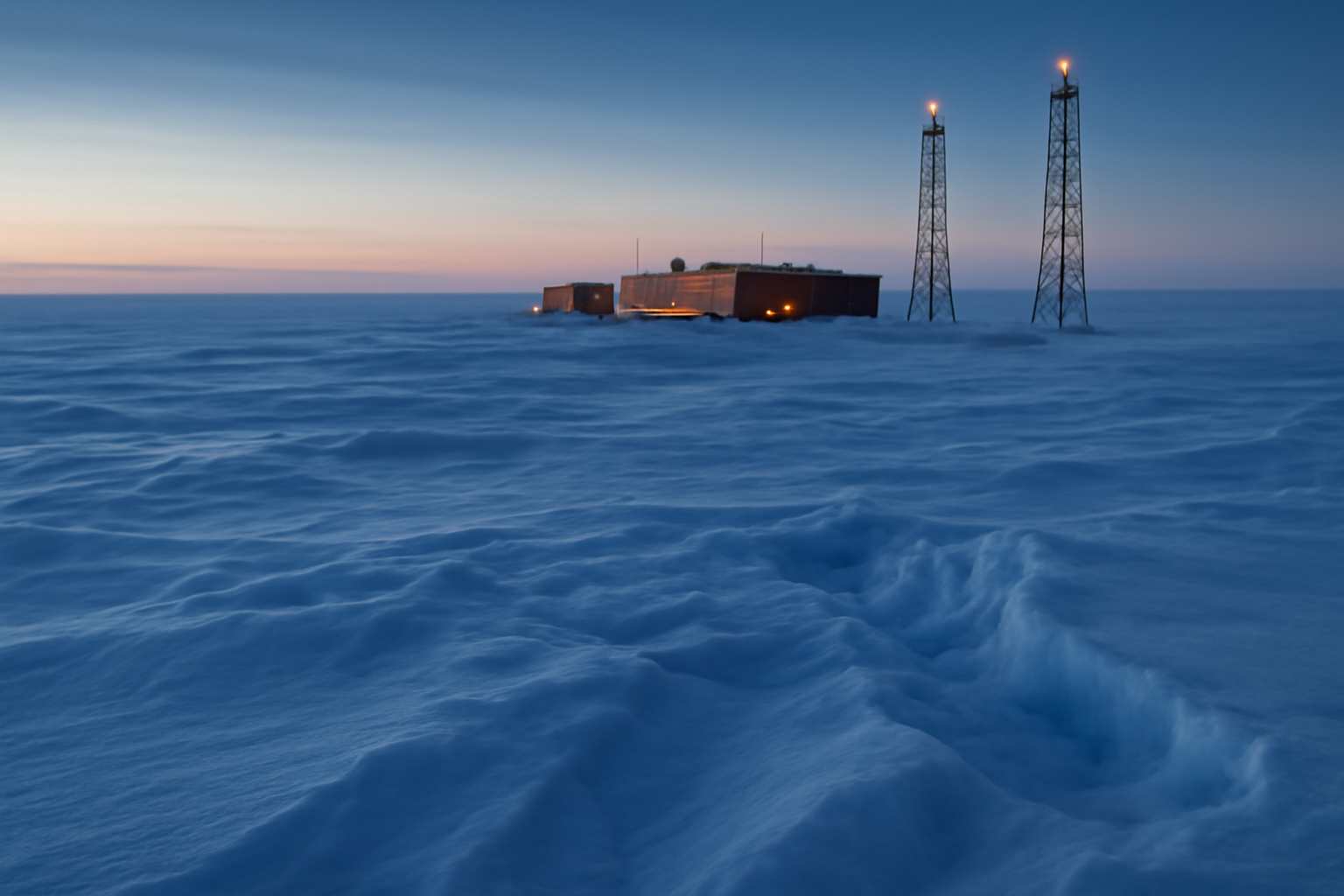 Rows of frozen sensor cables descending into South Pole ice at the IceCube neutrino observatory