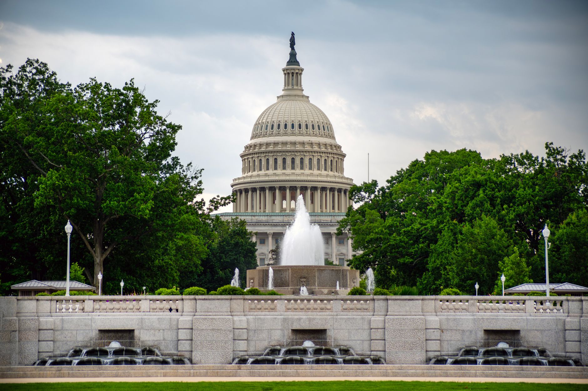 A ballot box sits beside a row of microphones in front of the US Capitol dome at dusk