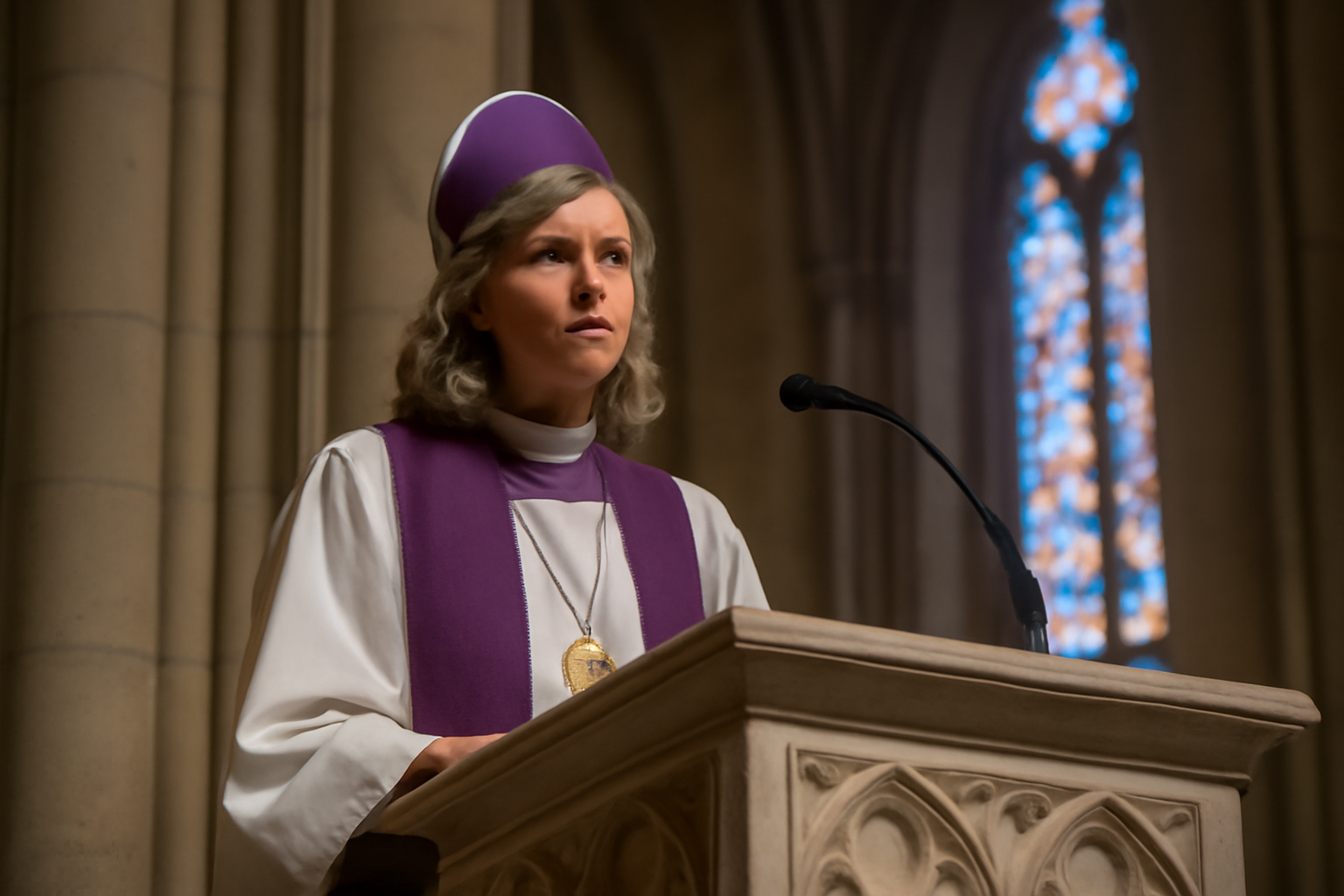 Episcopal bishop in white vestments speaking from a cathedral pulpit
