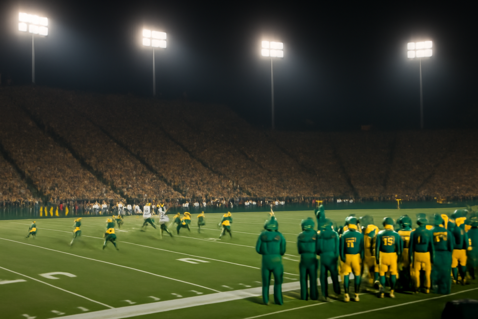 Oregon Ducks football player in uniform standing on the sideline at a night game