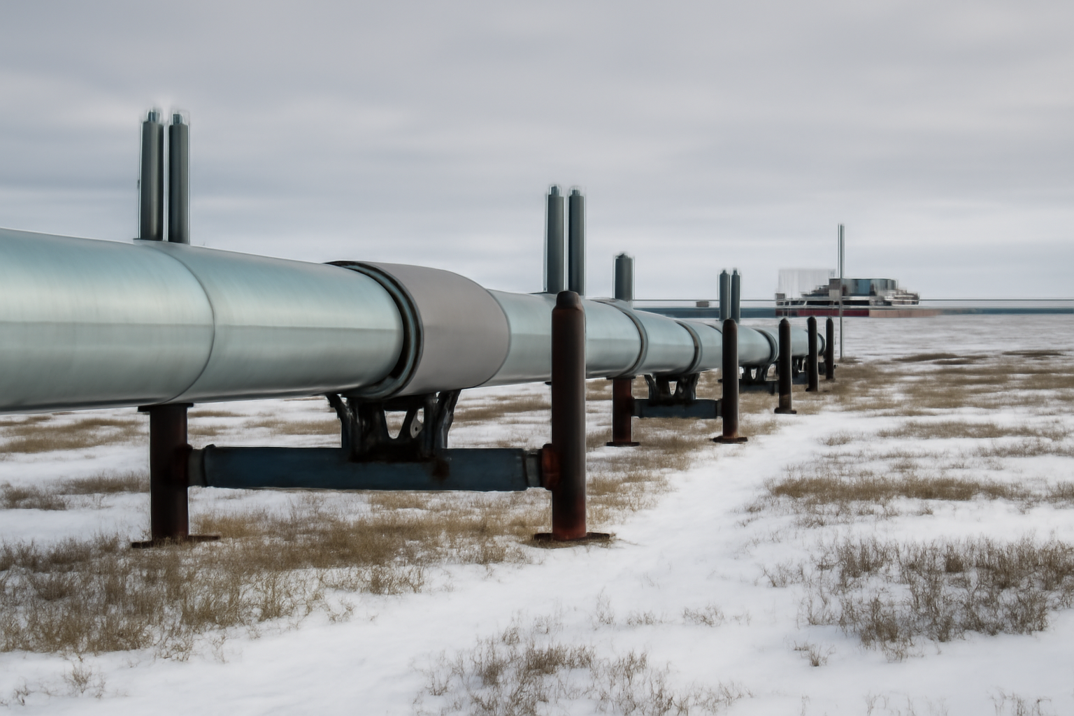 Natural gas pipeline infrastructure in a snowy Alaska landscape with industrial equipment