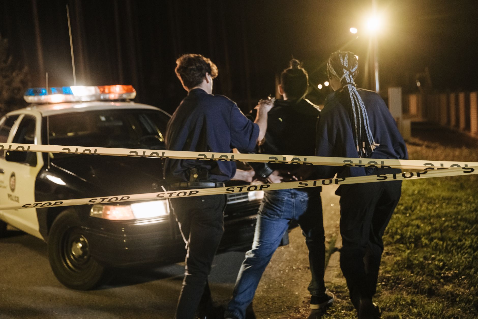 Police tape and patrol vehicles outside a Tallahassee neighborhood near Florida A&M University at night