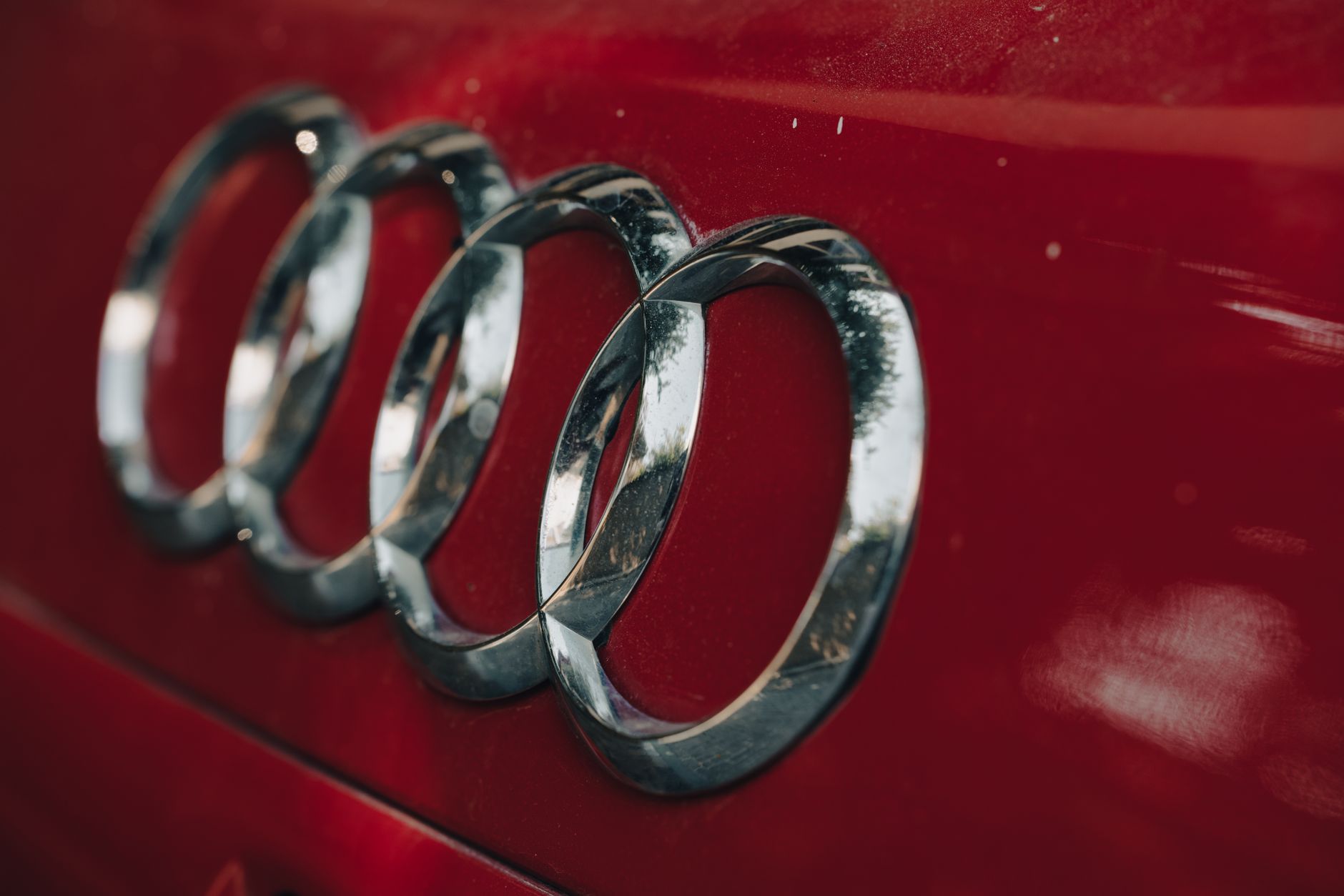 Exterior of an Audi dealership showroom with the brand logo visible above the entrance