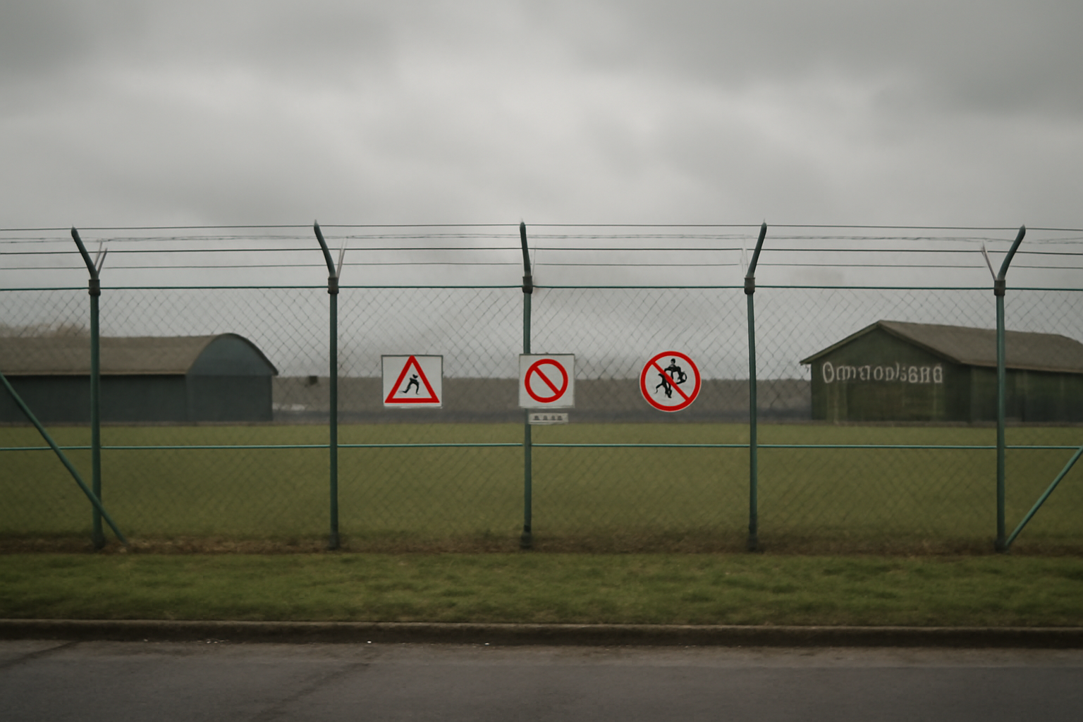 Exterior view of a Royal Air Force base perimeter fence under overcast sky
