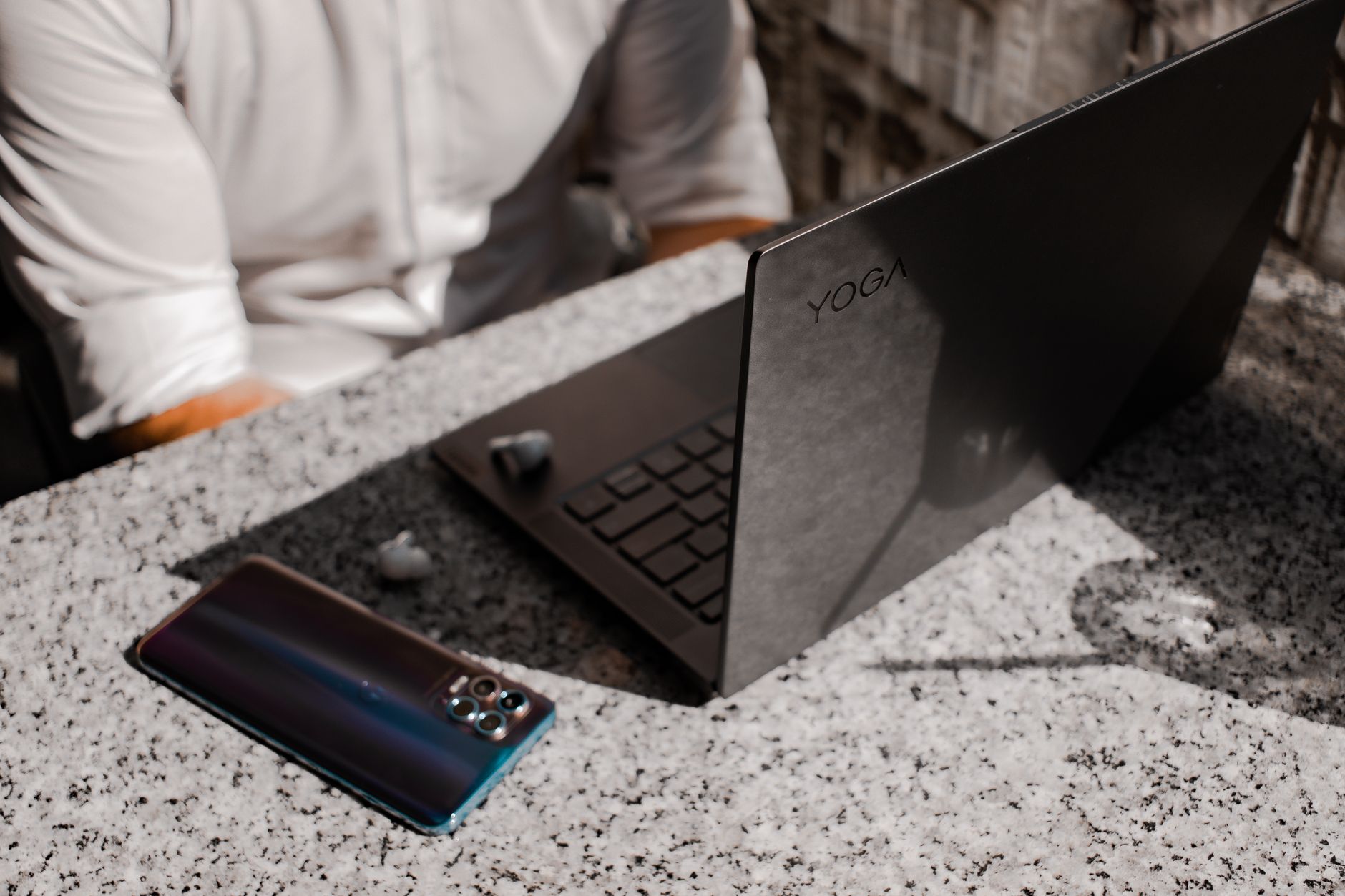 A convertible 2-in-1 laptop folded into tablet mode next to a traditional clamshell laptop on a desk.