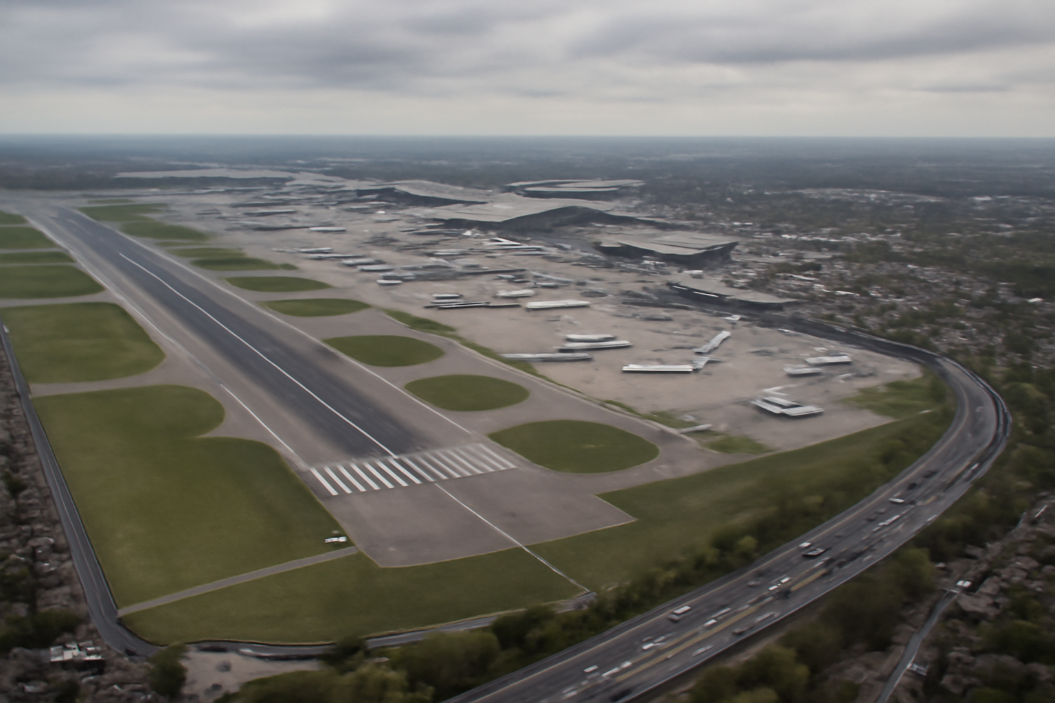 Aerial view of Heathrow Airport runways with planes on the tarmac and London suburbs in the background