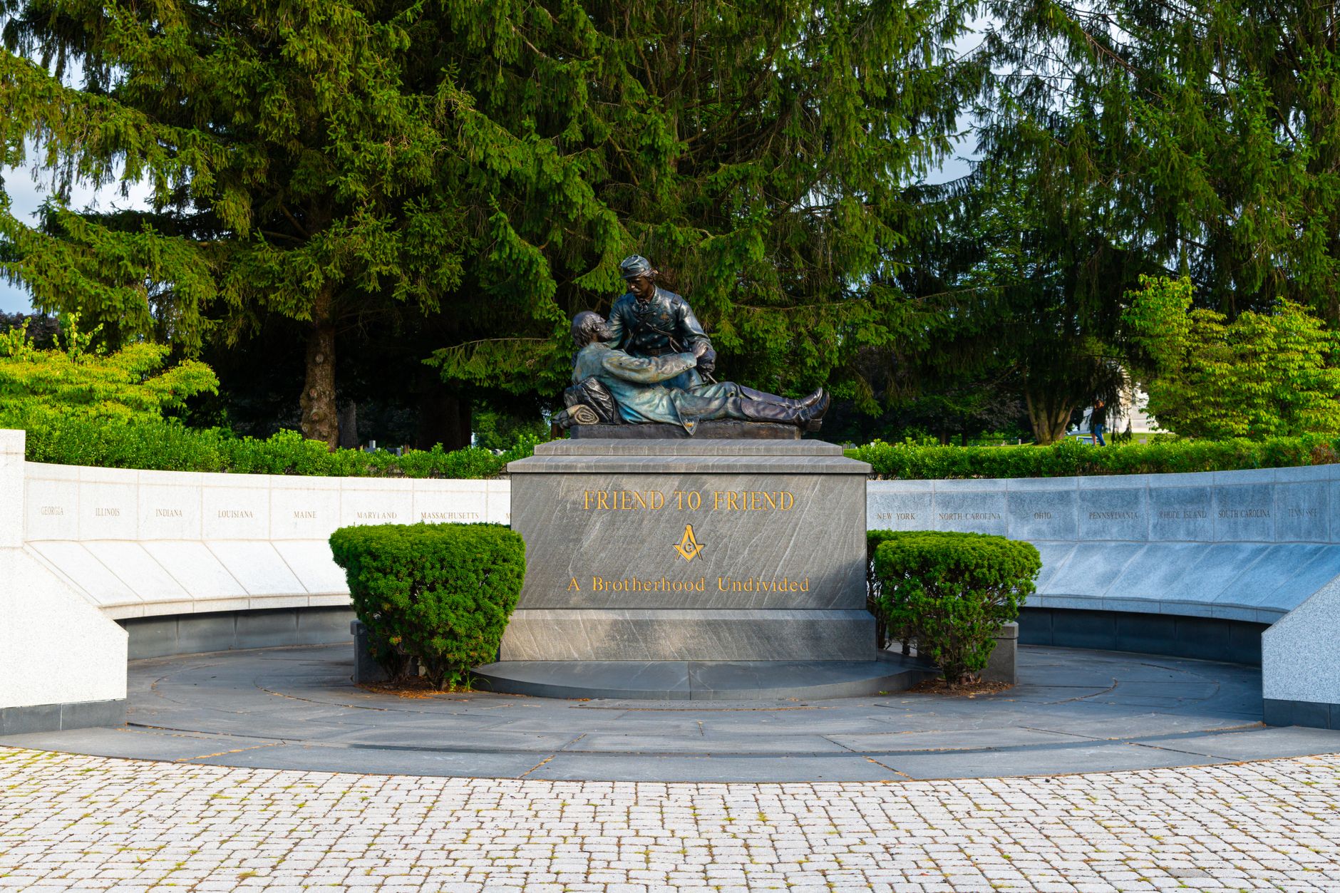 Bronze Iwo Jima memorial statue of Marines raising a flag, with damage visible on one figure's head, near a military base