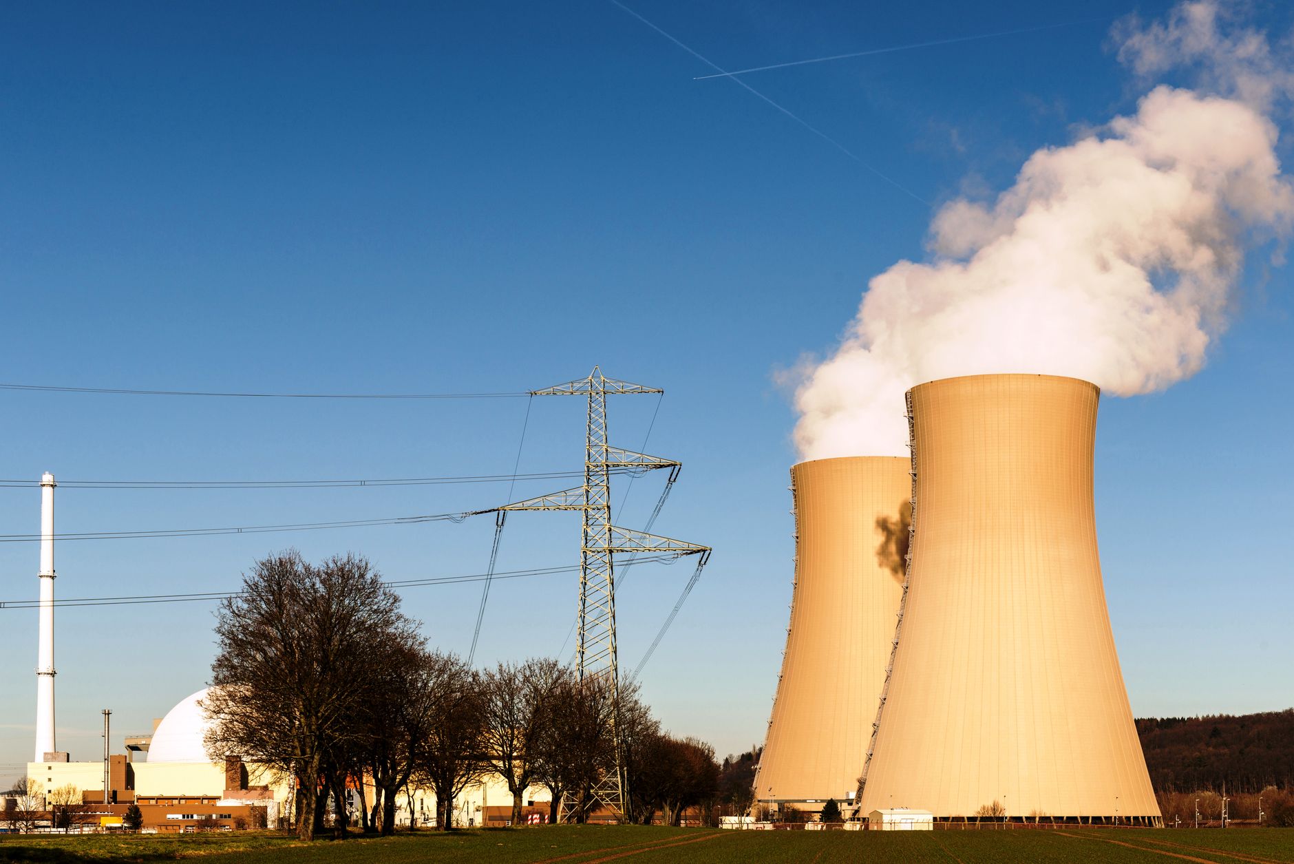 Cooling towers rising from a nuclear power plant against a clear sky