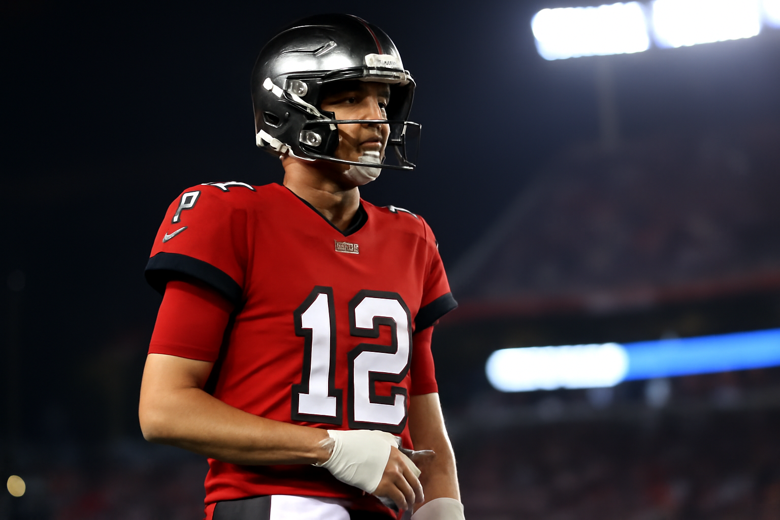 Tampa Bay Buccaneers quarterback on the sideline with his right hand wrapped, watching the game